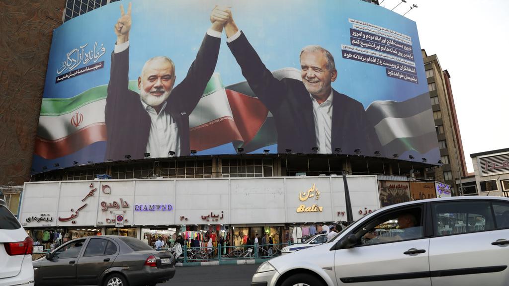 德黑蘭市中心展示哈尼亞(左)與伊朗總統佩澤斯基安展現友好的巨幅海報。(美聯社)