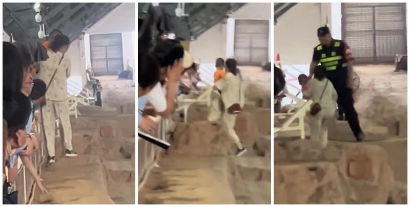 一名母親抱孩子參觀時，突直接跨過護欄走在兵馬俑坑坑道上，最終被保安帶走。(影片截圖)