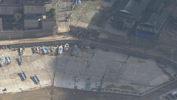 有被孤立地區居民擺出SOS字樣及人數求救。(新聞截圖)