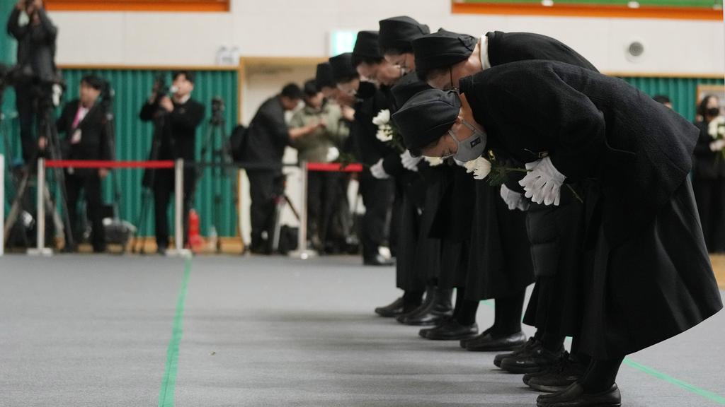 濟州航空客機空難造成179人死亡，南韓多地設置臨時靈堂，圖為民眾到務安體育公園靈堂，向死難者致祭。(美聯社)