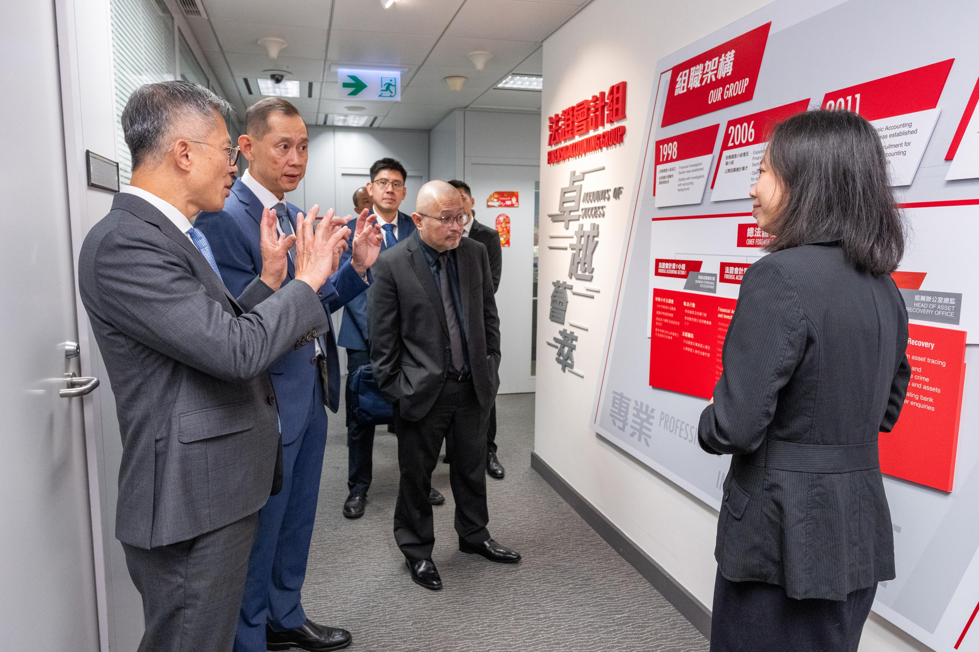 副廉政專員及執行處首長丘樹春（左一）向新加坡貪污調查局局長鄭忠輝（左二）介紹廉署法證會計組工作。