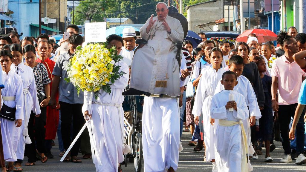 東帝汶教徒捧著紙版方濟各，上街遊行悼念。(美聯社)