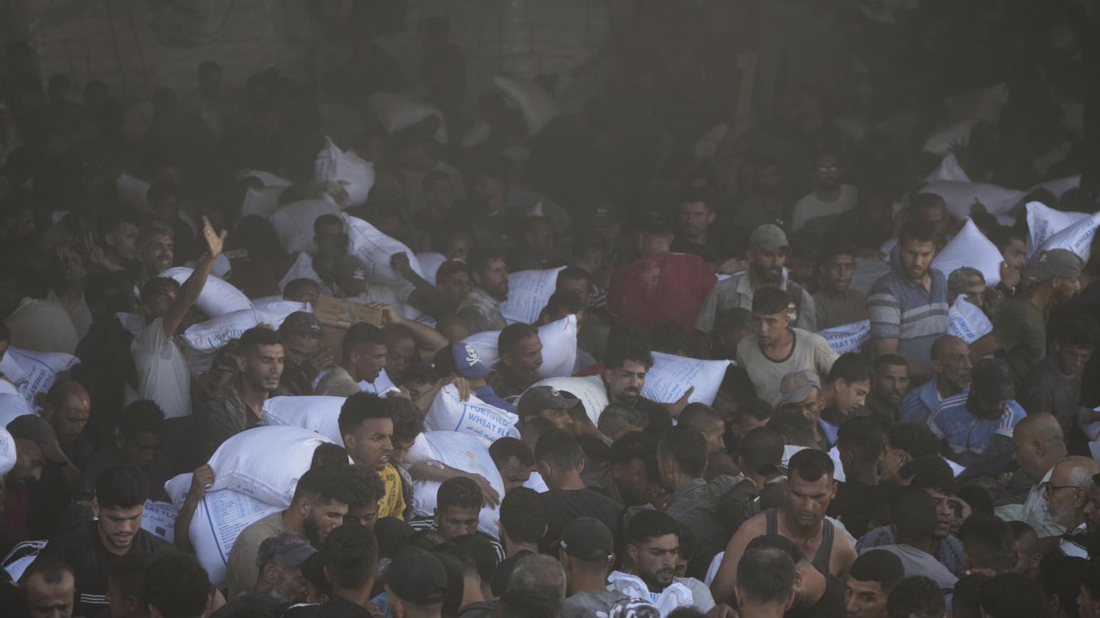 一處位於加沙走廊中部的聯合國世界糧食計劃署倉庫，28日遭當地民眾湧入搶奪麵粉。（圖/美聯社）