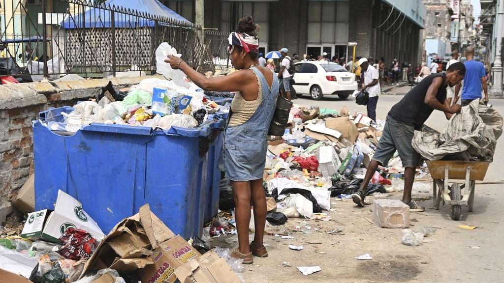 古巴女性在垃圾箱內尋找物品。(美聯社)