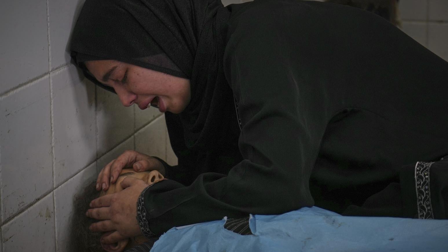 7月10日，一名巴勒斯坦女子在姊妹的遺體旁痛哭。死者薩瑪（Sama）在「希望工程」診所等待領取營養補充劑時命喪以色列襲擊。（圖／美聯社）