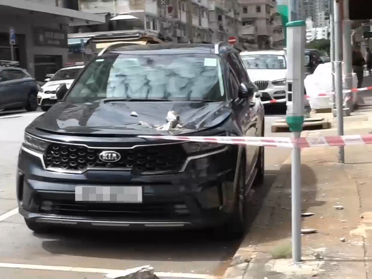 土瓜灣工廈簷篷石屎剝落，砸爛私家車車頭幸無人受傷。(有線新聞截圖)