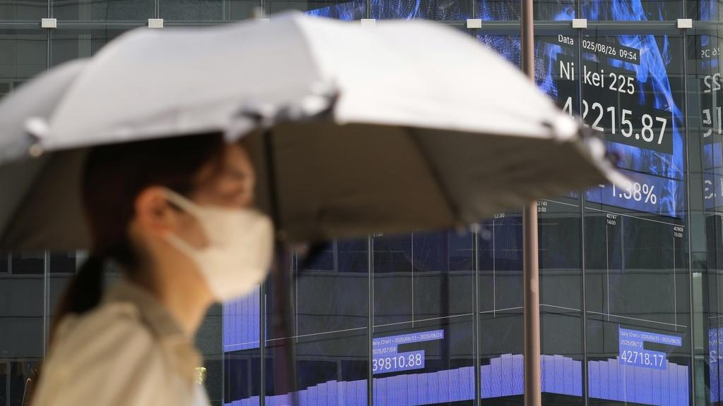 東京酷熱，民眾外出時撐傘擋太陽。(美聯社)