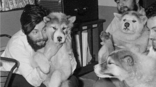 失蹤多年的英國南極研究員比爾（左）在南極基地內與雪橇犬玩耍。(英國南極調查局)