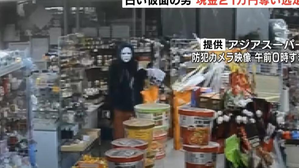 劫匪戴著白色面具，身穿黑外套，深夜持刀進入超市。(互聯網)