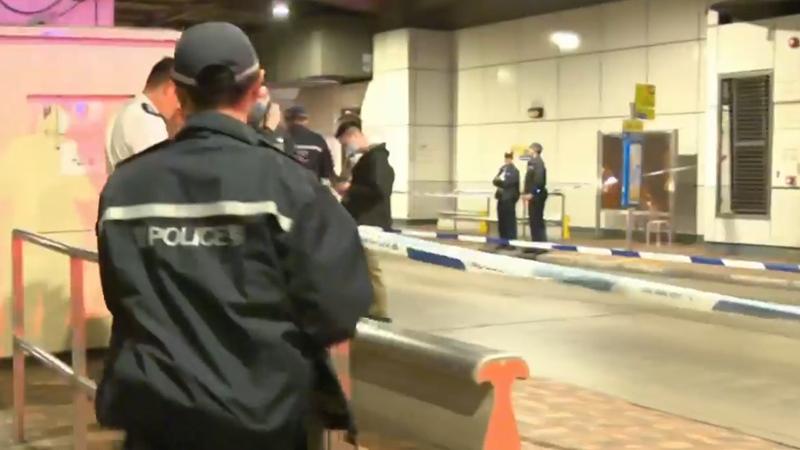 金鐘巴士站男子捱斬浴血送院，警追緝2兇徒。(有線新聞截圖)