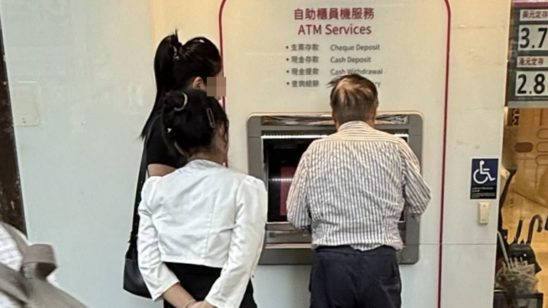 目擊有阿伯在使用自動櫃員機時，旁邊站了2名女子。(Threads)