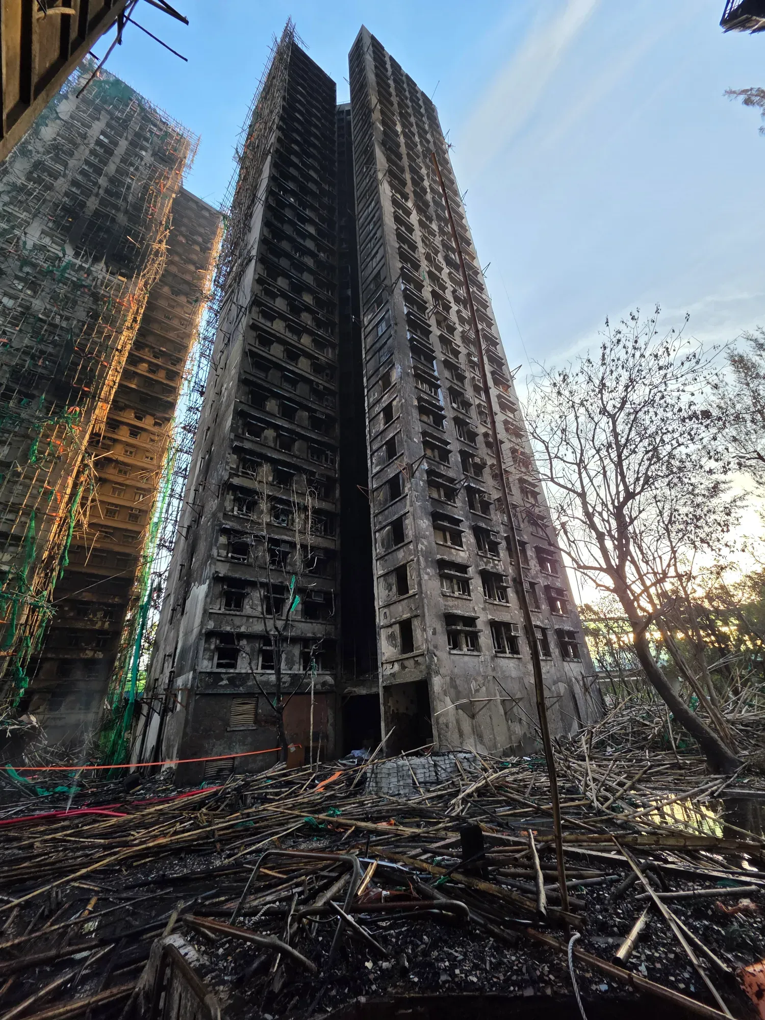 有消防於社交平台發布宏福苑現場震撼照片，可見如同「戰後廢墟」滿目瘡痍，有大廈嚴重熏黑，外圍棚網已全部被燒毀，大量竹棚掉下散滿空地。(Threads)