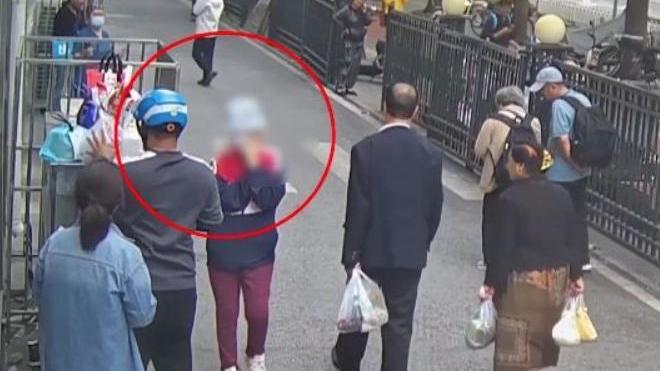 趙女（紅圈處）戴上口罩和帽子偷架子上的外賣。（圖／翻攝《網易》）