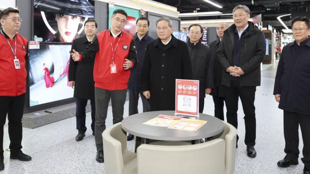 李強在一間電器店了解銷售情況。（新華社）