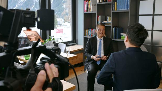 陳茂波（左）在出席年會期間接受傳媒訪問。（政府新聞處）